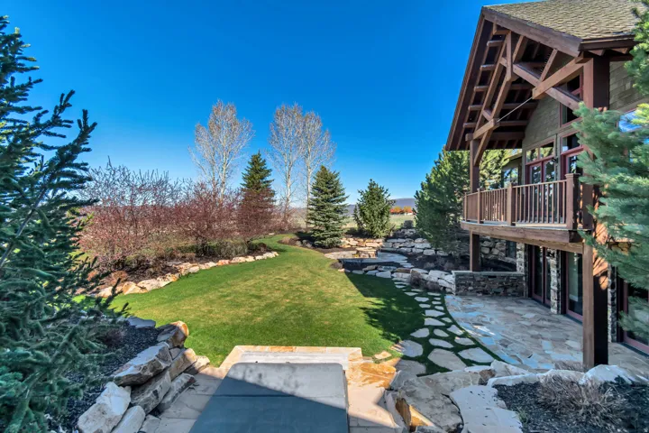 View of grassy yard with a patio area