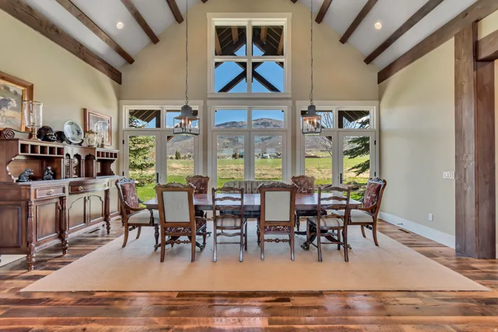 Dining room with a mountain view, dark wood-style floors, vaulted ceiling, and recessed lighting