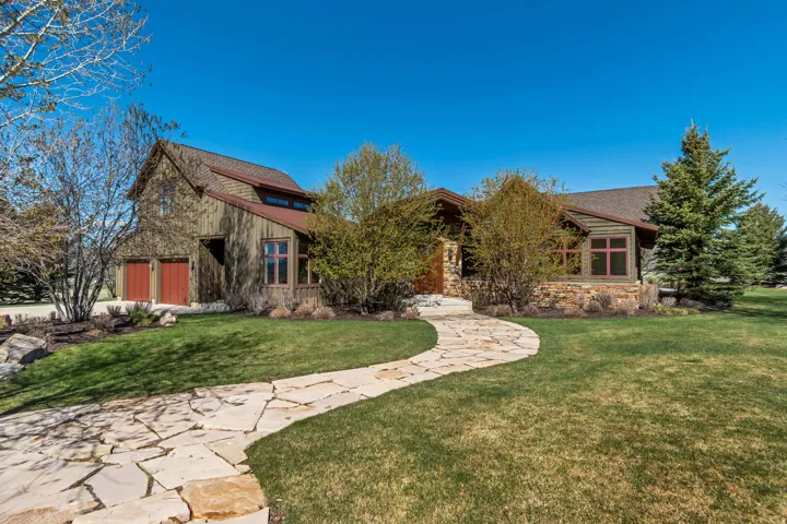 View of front of property with a front lawn and stone siding