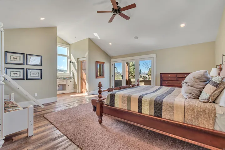 Bedroom with access to outside, light wood finished floors, ceiling fan, recessed lighting, and lofted ceiling