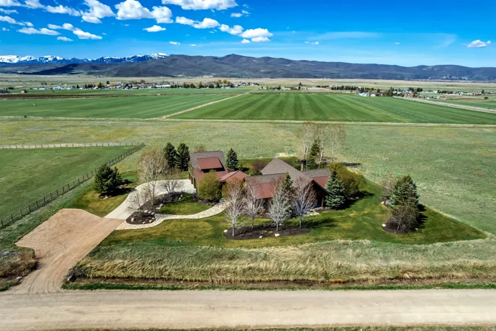 Aerial view of sparsely populated area with agricultural land and a mountain backdrop