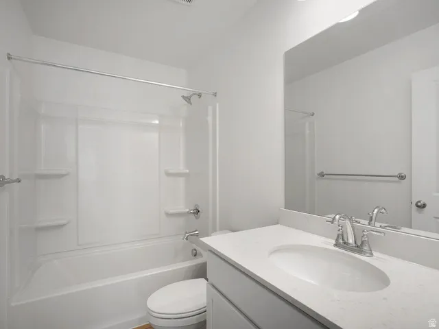 Bathroom featuring a full vanity with a white countertop and integrated sink, chrome faucet, and a large wall-mounted mirror