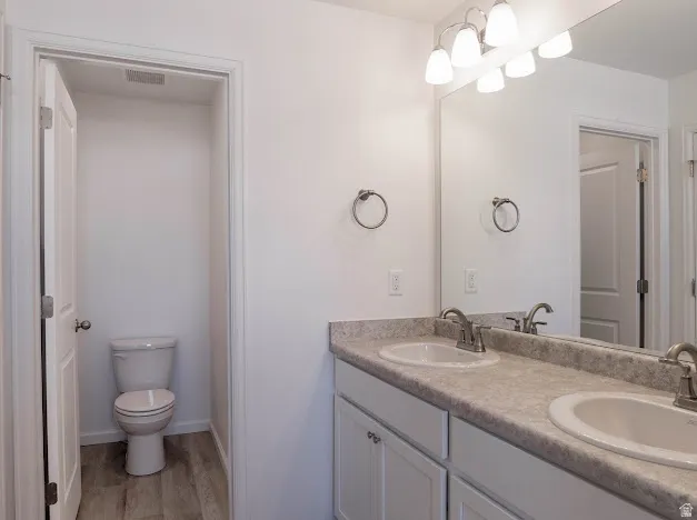 Bathroom with double vanity and light wood finished floors