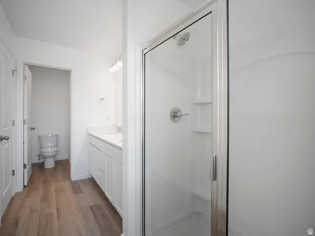 Glass-enclosed shower with chrome fixtures and integrated shelving