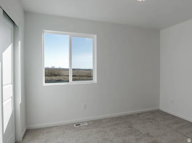 Empty room with light colored carpet