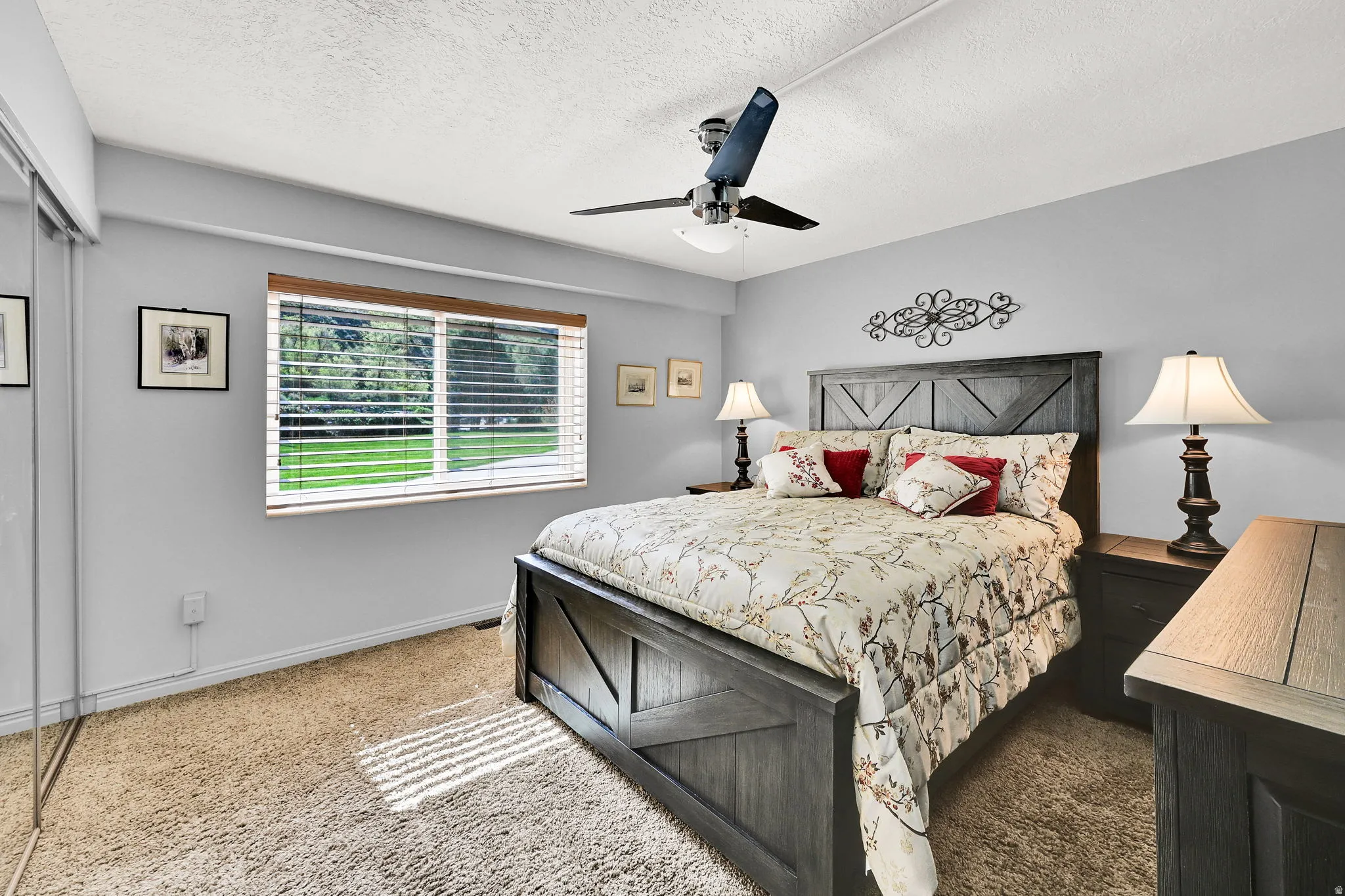 Carpeted large bedroom featuring ceiling fan