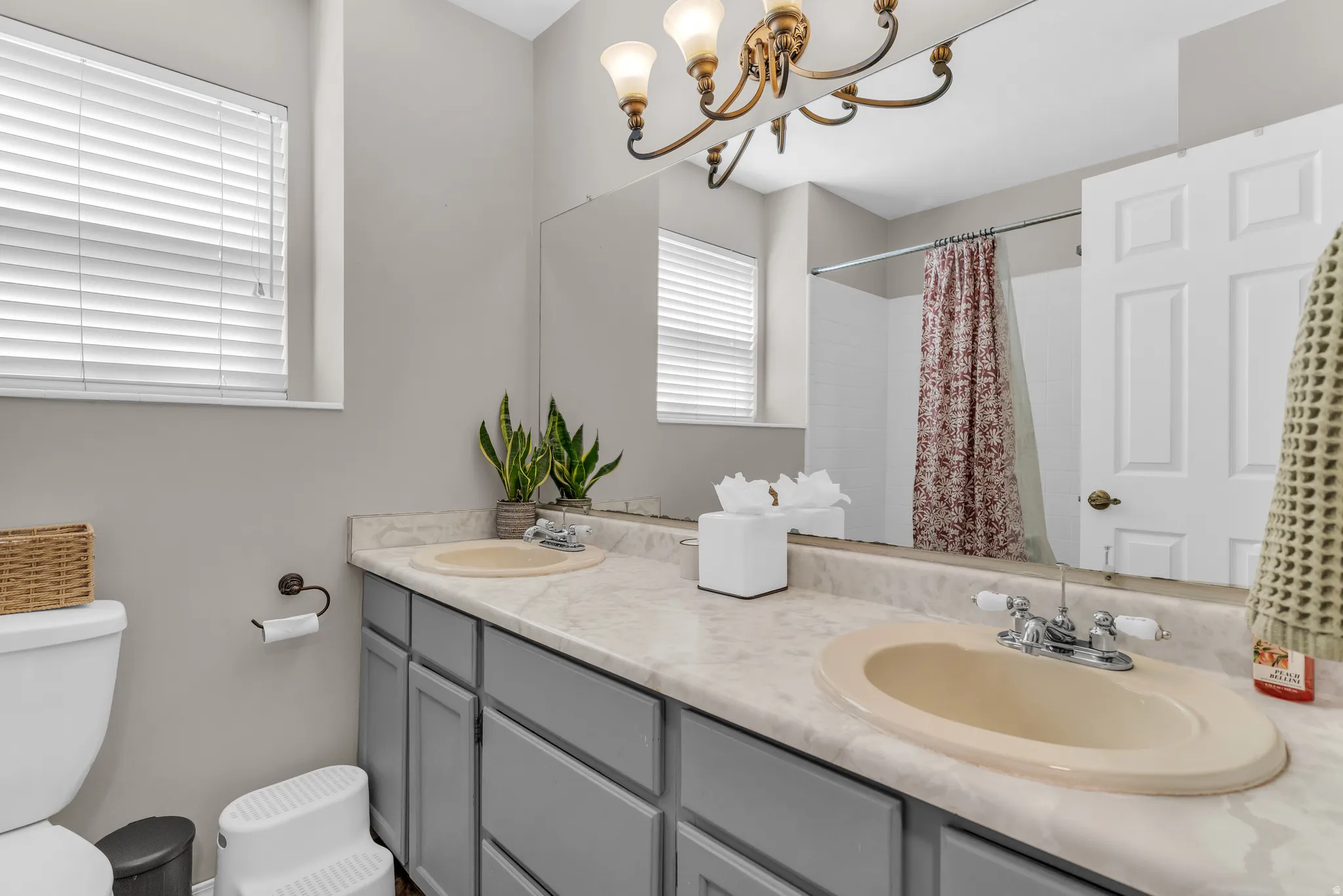 Full bathroom featuring double vanity, a shower with curtain, and hanging lights