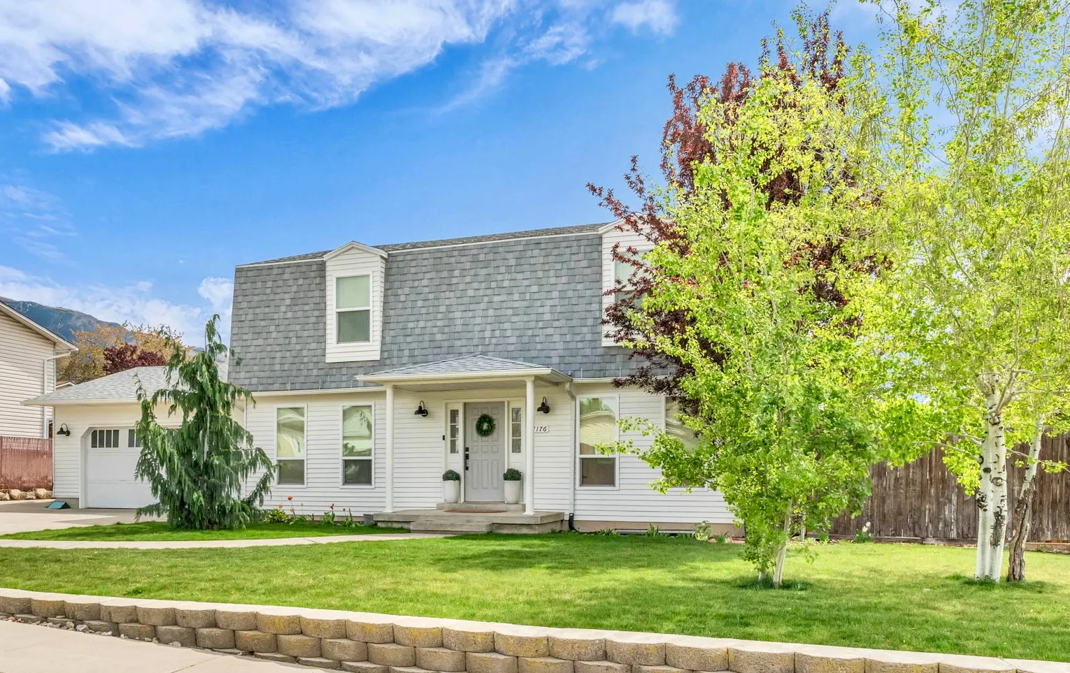 View of front of property featuring roof with shingles, a garage, and driveway