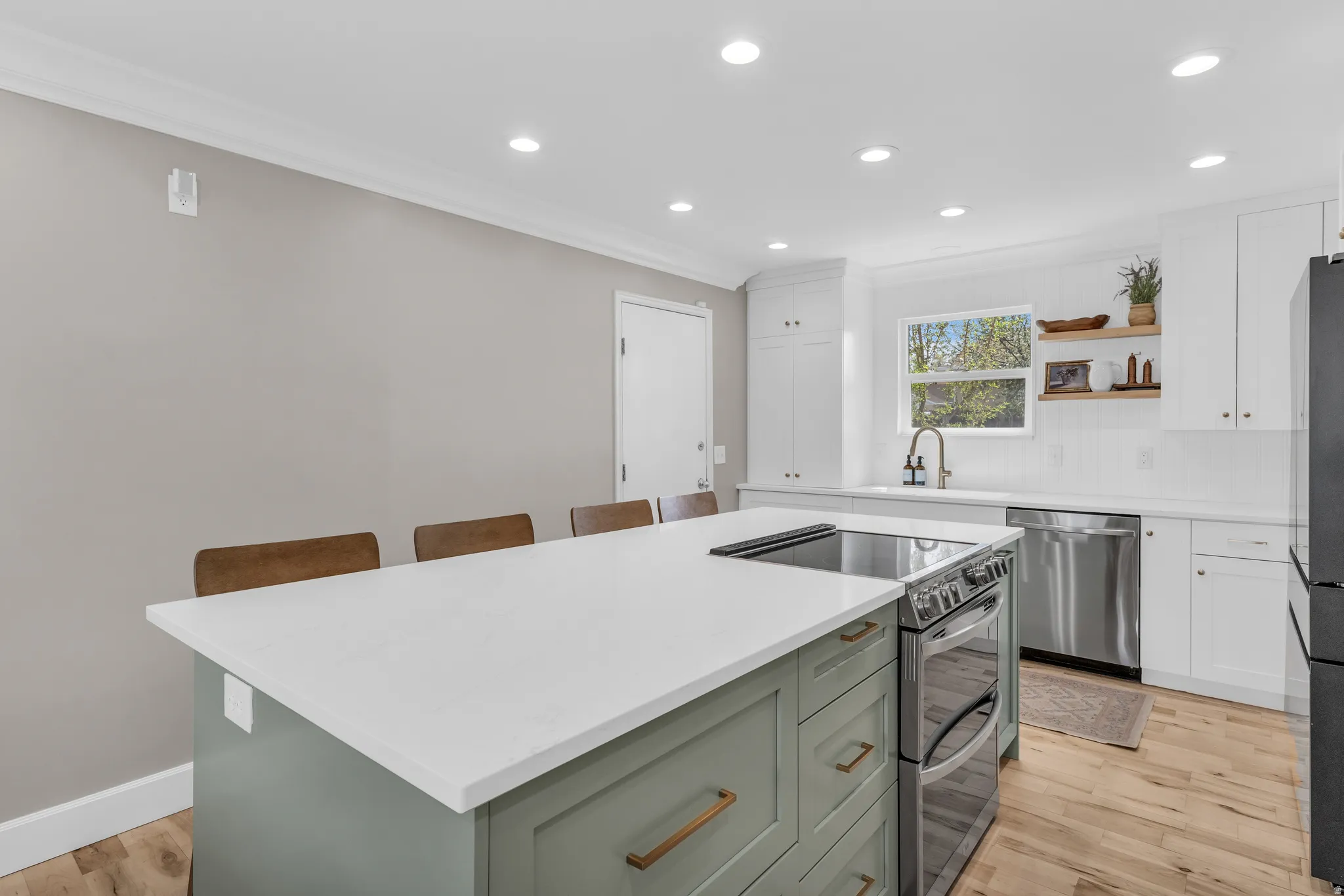 Two tone kitchen with crown molding, stainless steel appliances, recessed lighting, two tone cabinetry, and open shelves
