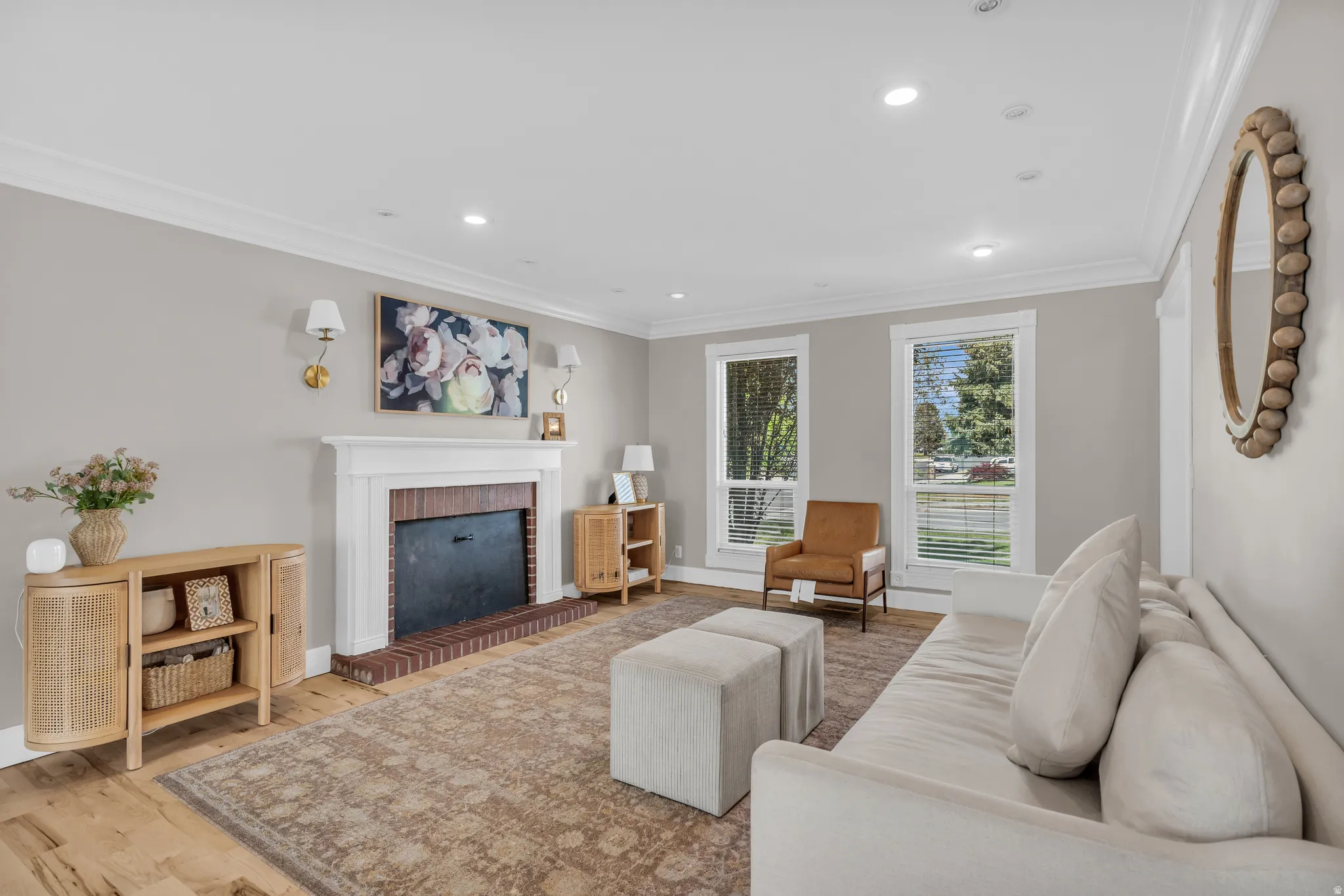 Living area featuring ornamental molding, light wood-type flooring, recessed lighting, and a fireplace