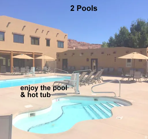 Community pool with a patio, outdoor dining space, and a mountain view near the office.