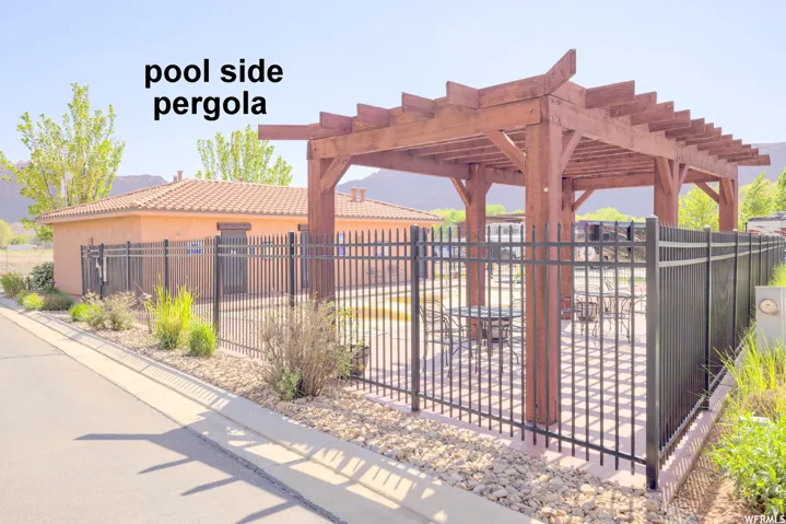 View of community area with a pergola and a patio area near the dog park.