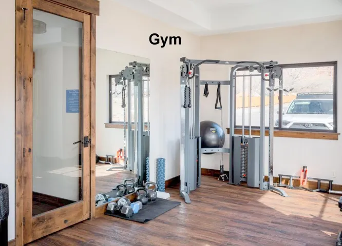 Workout area featuring dark wood-style floors and baseboards