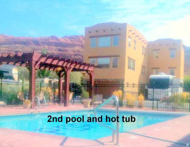 Community pool with a pergola and a patio near the dog park.