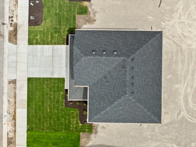 Pitched shingle roof with multiple vents and a finished concrete driveway