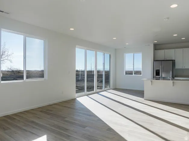 Unfurnished living room with dark wood-style floors and recessed lighting
