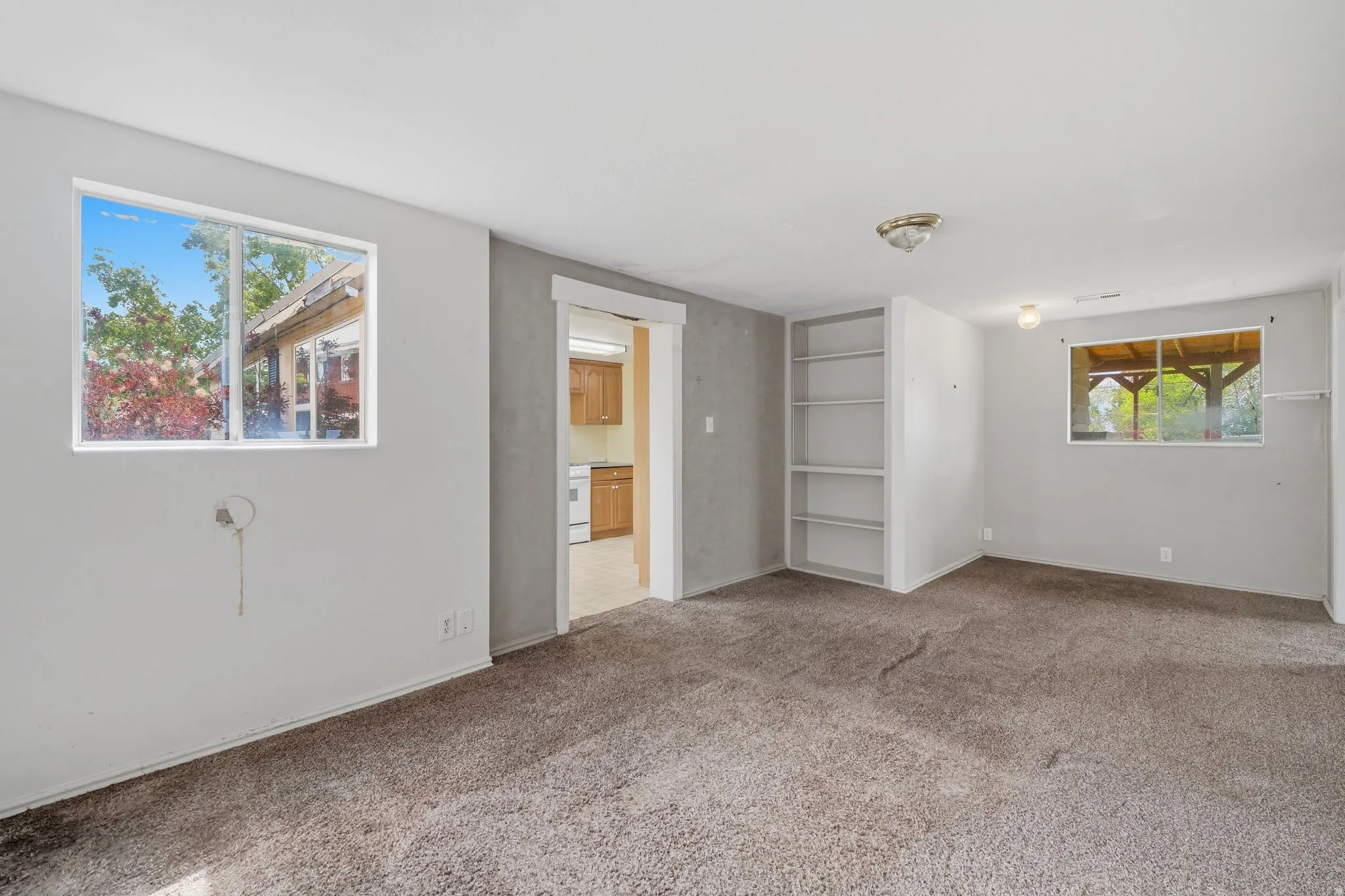 Unfurnished bedroom featuring multiple windows and carpet flooring