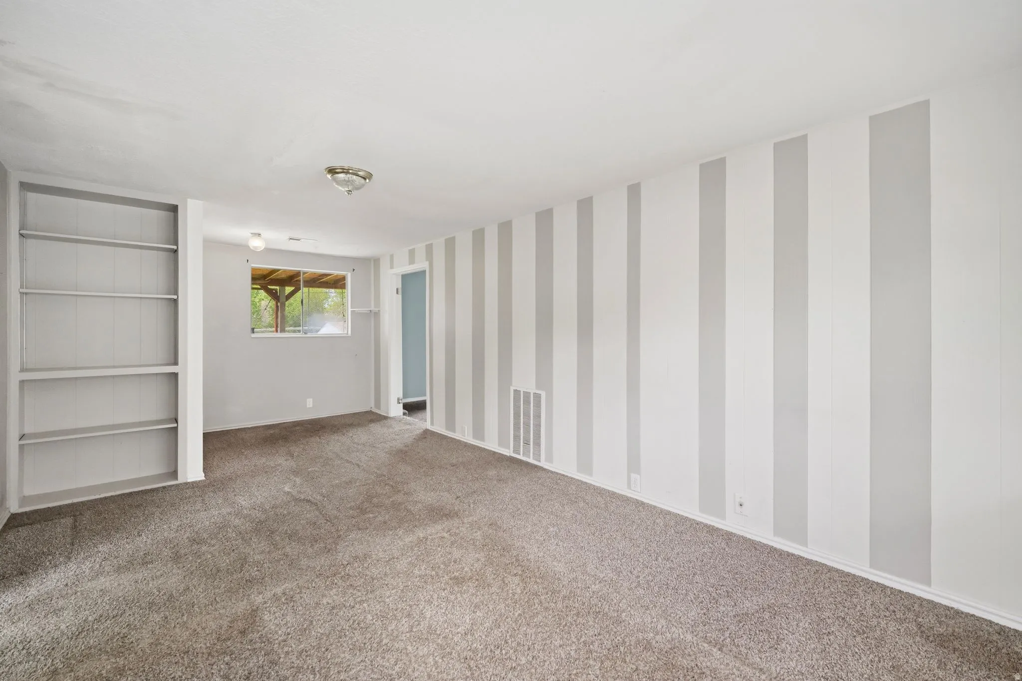 Empty room with carpet floors and wallpapered walls