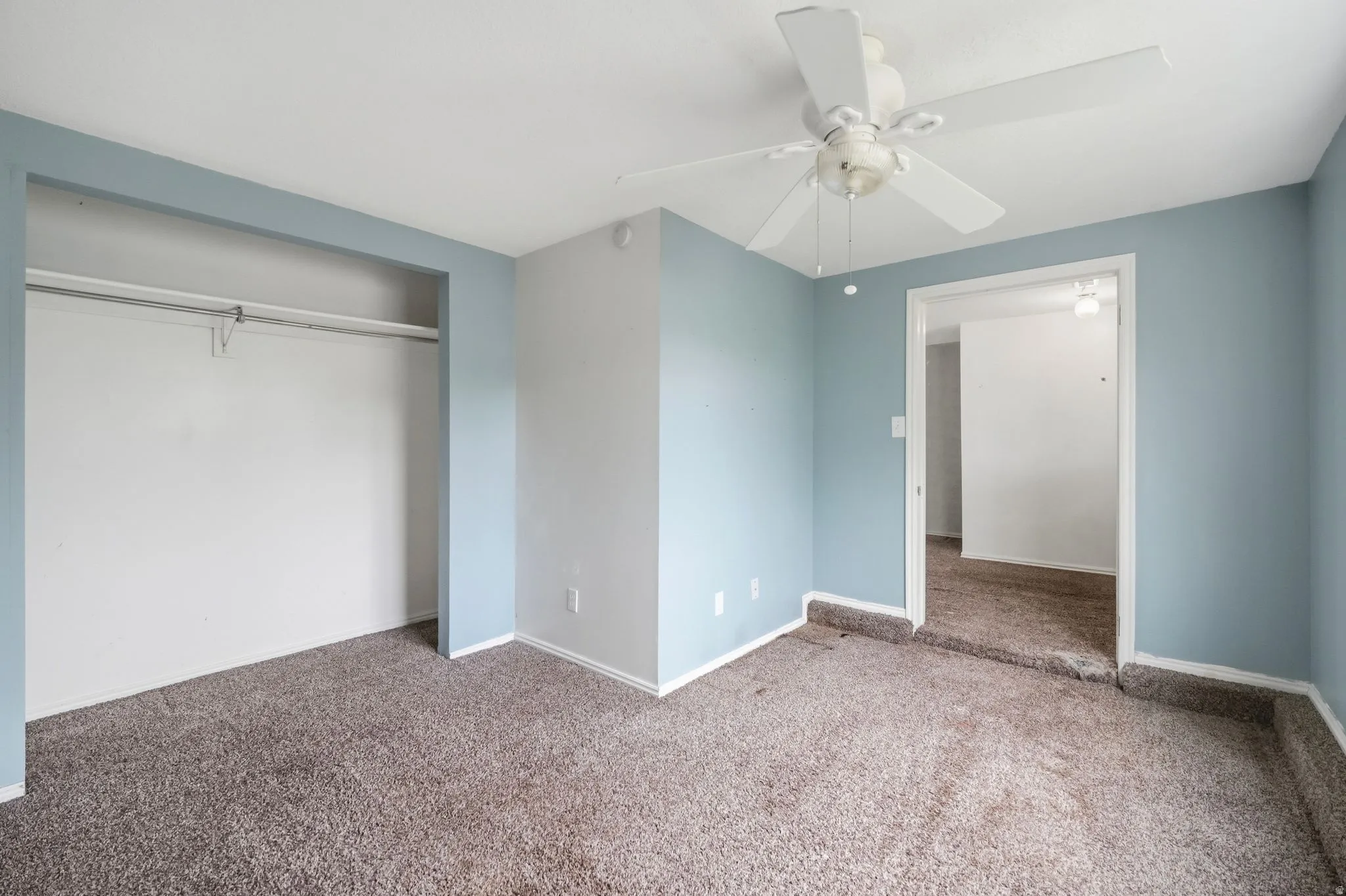 Unfurnished bedroom with carpet floors, a closet, and ceiling fan