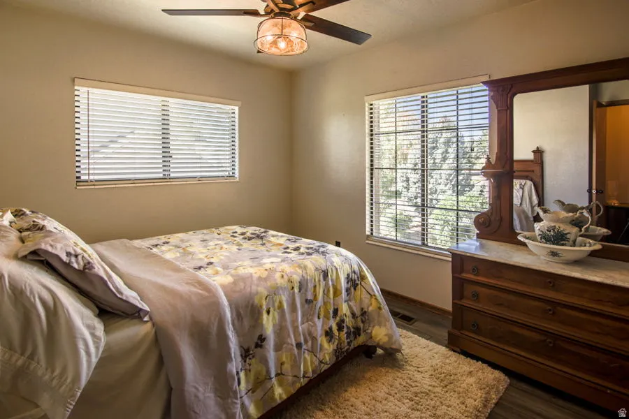 Bedroom #3 with dark wood finished floors and ceiling fan. Lots of light with valley and mountain views