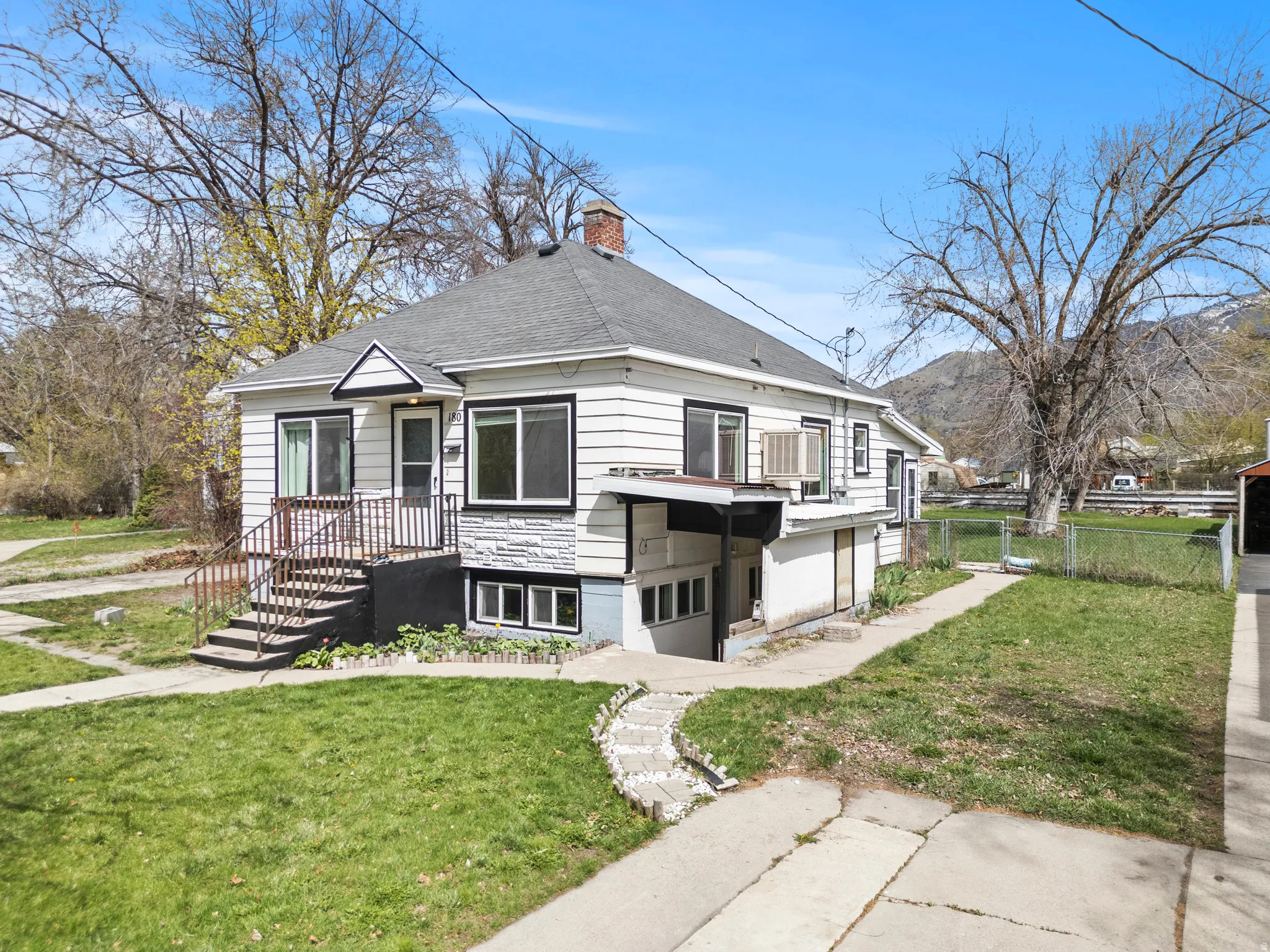 View of front of house featuring a chimney, roof with shingles, and a mountain view