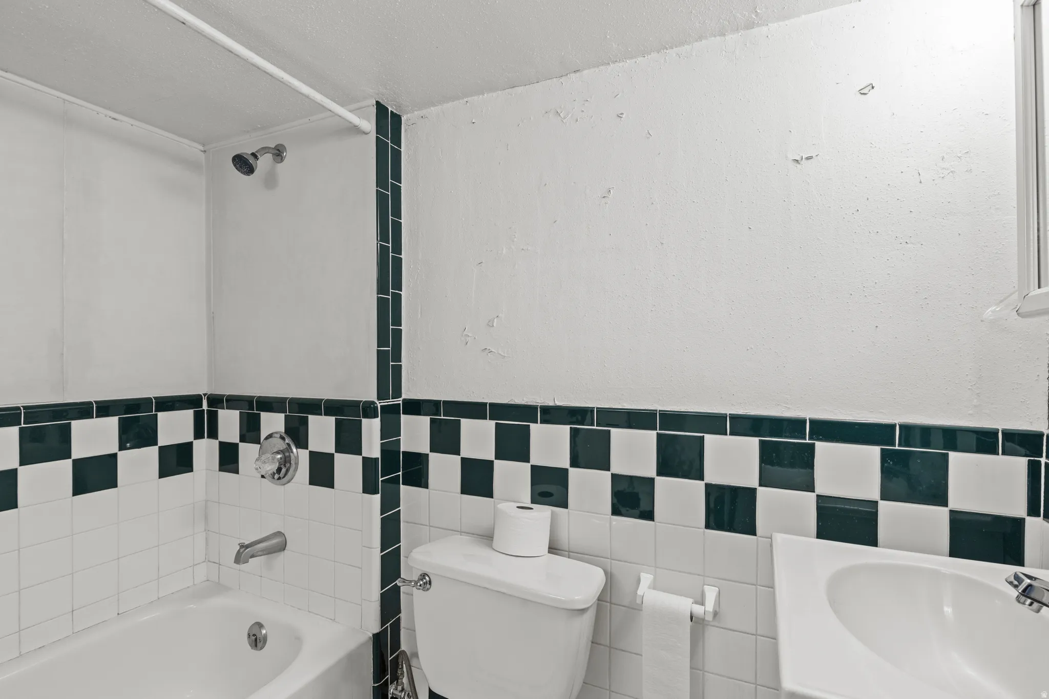 Bathroom with bathing tub / shower combination, tile walls, and vanity