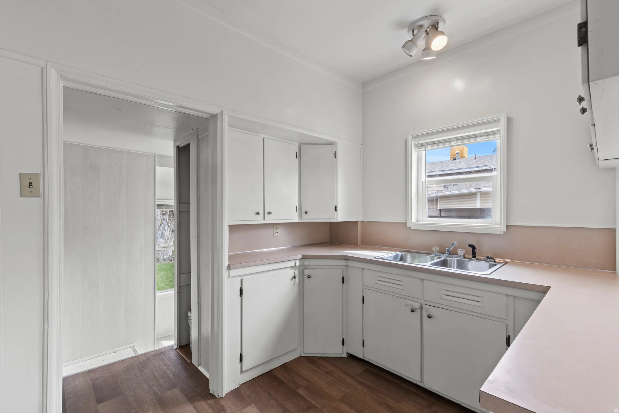 Kitchen featuring white cabinets, light countertops, and vinyl flooring