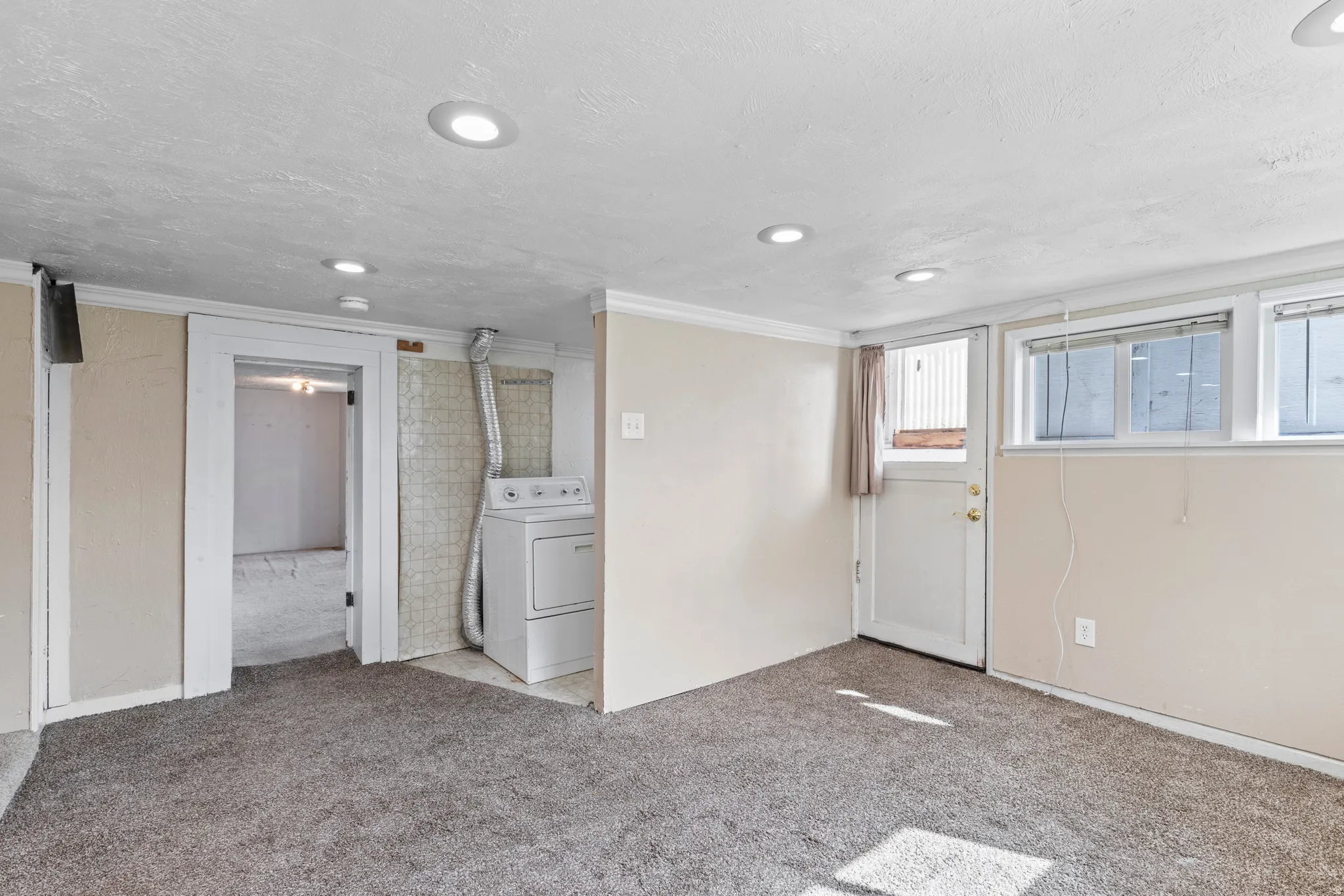 Basement featuring carpet, washer / clothes dryer, recessed lighting, and crown molding