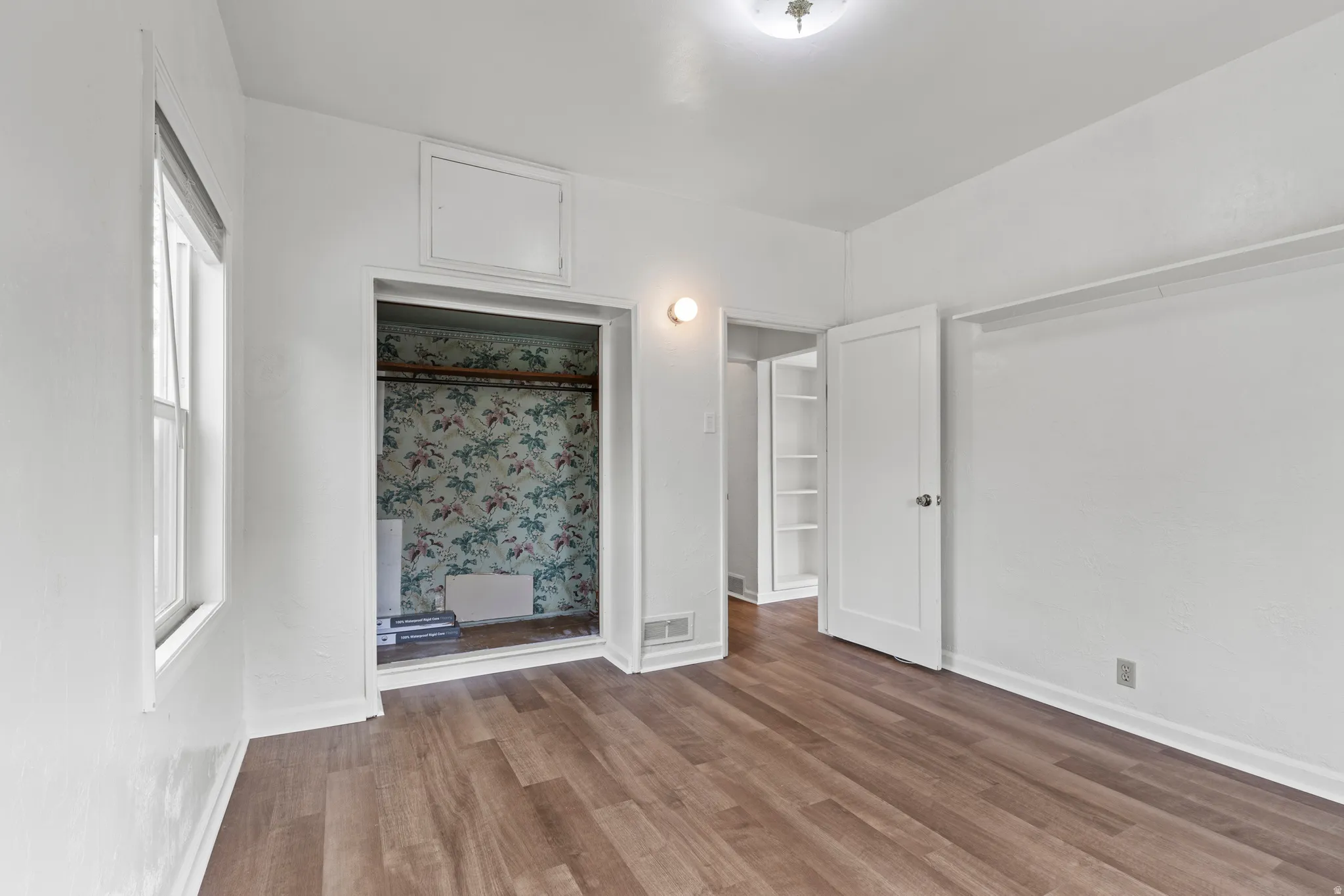 Unfurnished bedroom featuring vinyl floors and baseboards