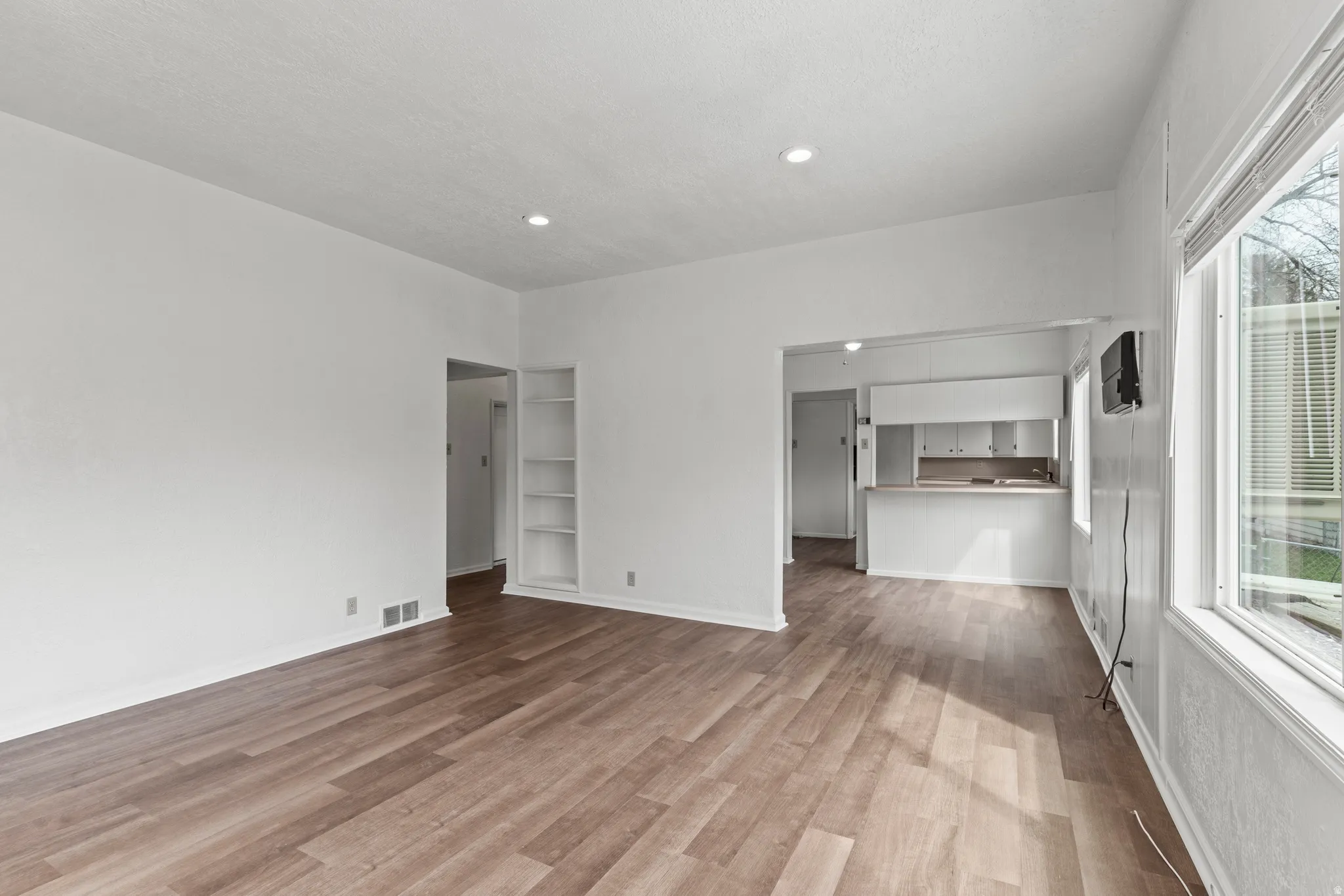 Unfurnished living room with light vinyl flooring and recessed lighting