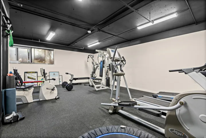 Dedicated exercise room featuring a dark ceiling, recessed lighting, and resilient flooring