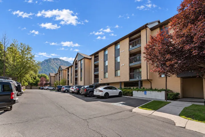 Modern multi-unit residential building featuring clean architectural lines, brick and stone exterior finishes, and contemporary balconies across multiple levels