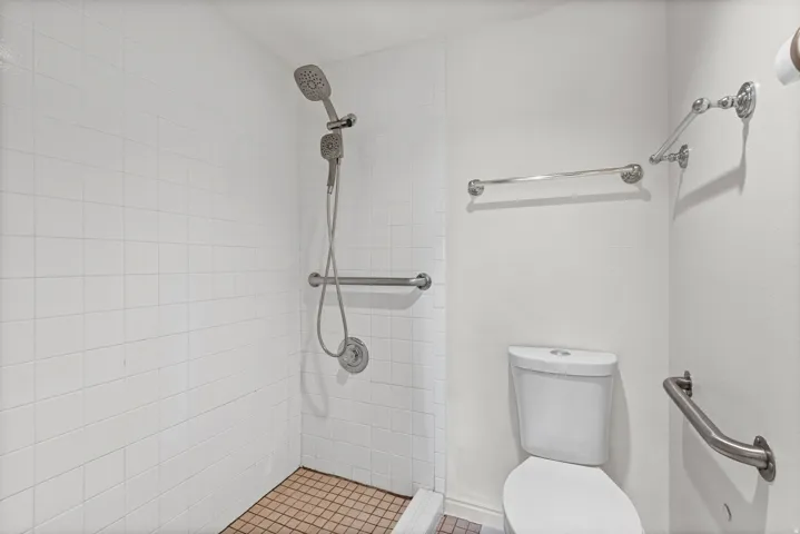 White subway tile shower surround with a handheld shower fixture
