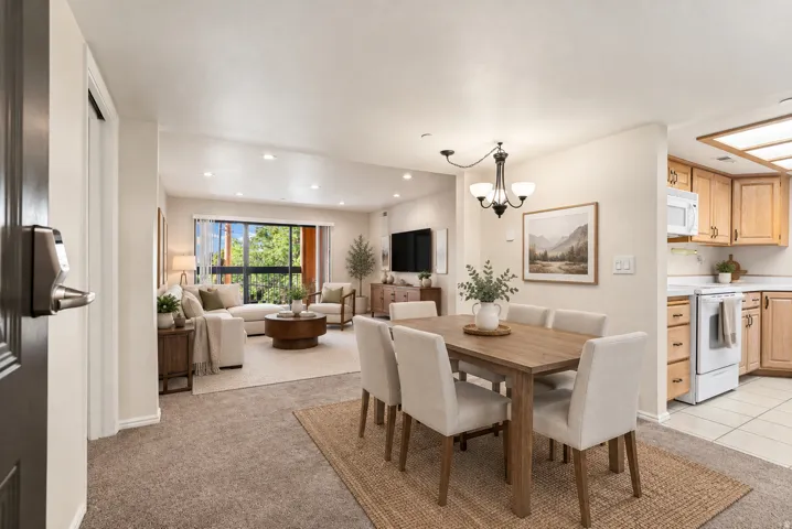 Open-concept living area with carpet flooring, vaulted ceilings, and recessed lighting
