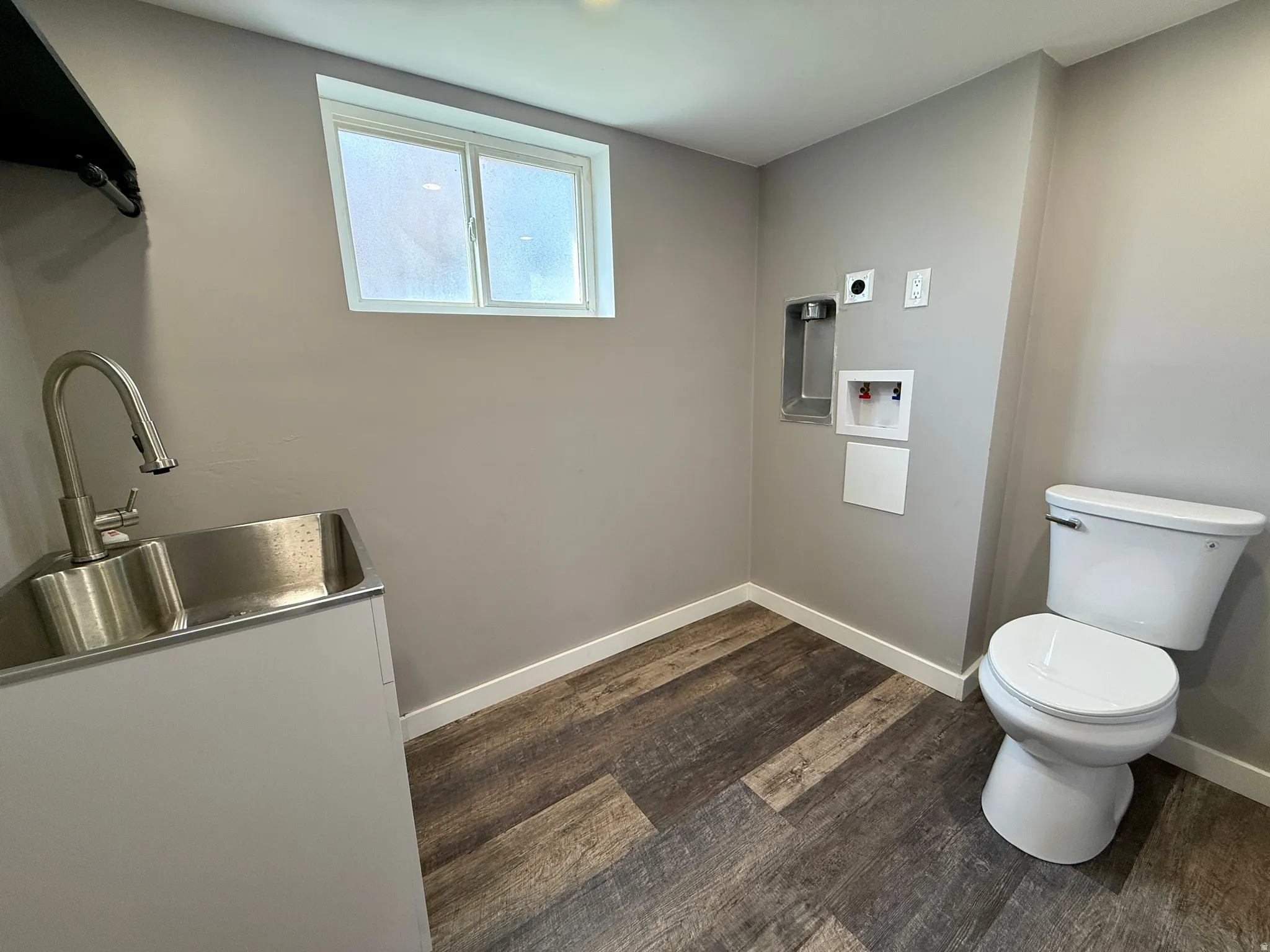 Laundry room featuring dark wood-style floors and washer hookup