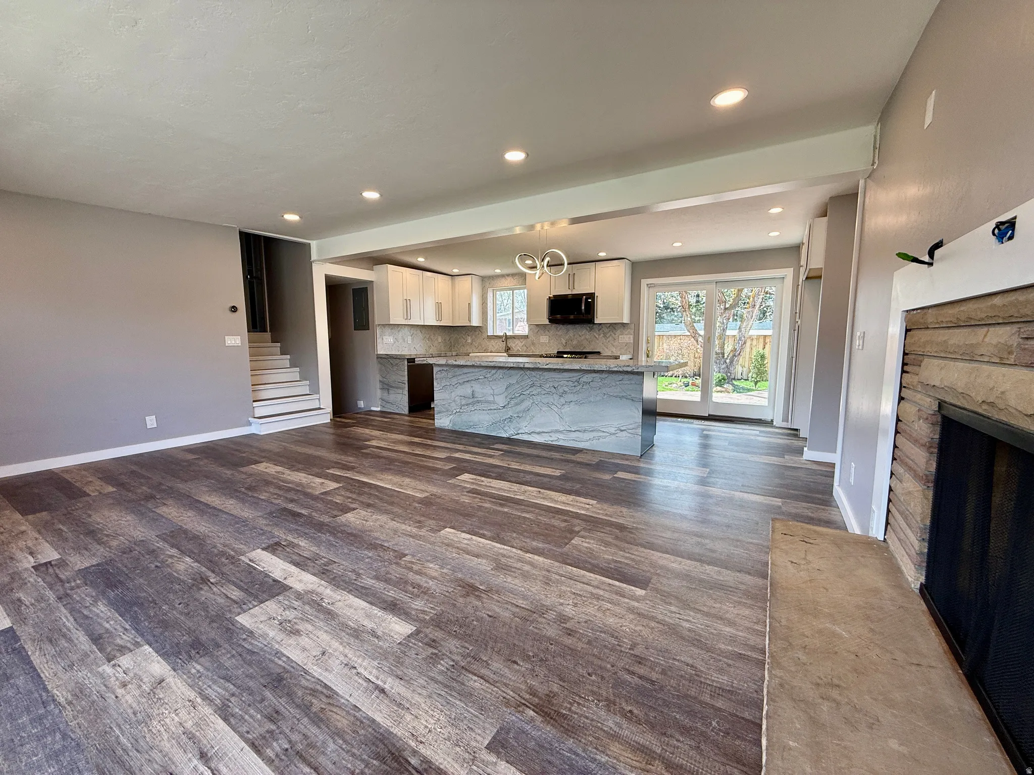 Unfurnished living room featuring dark wood finished floors, a fireplace, and recessed lighting
