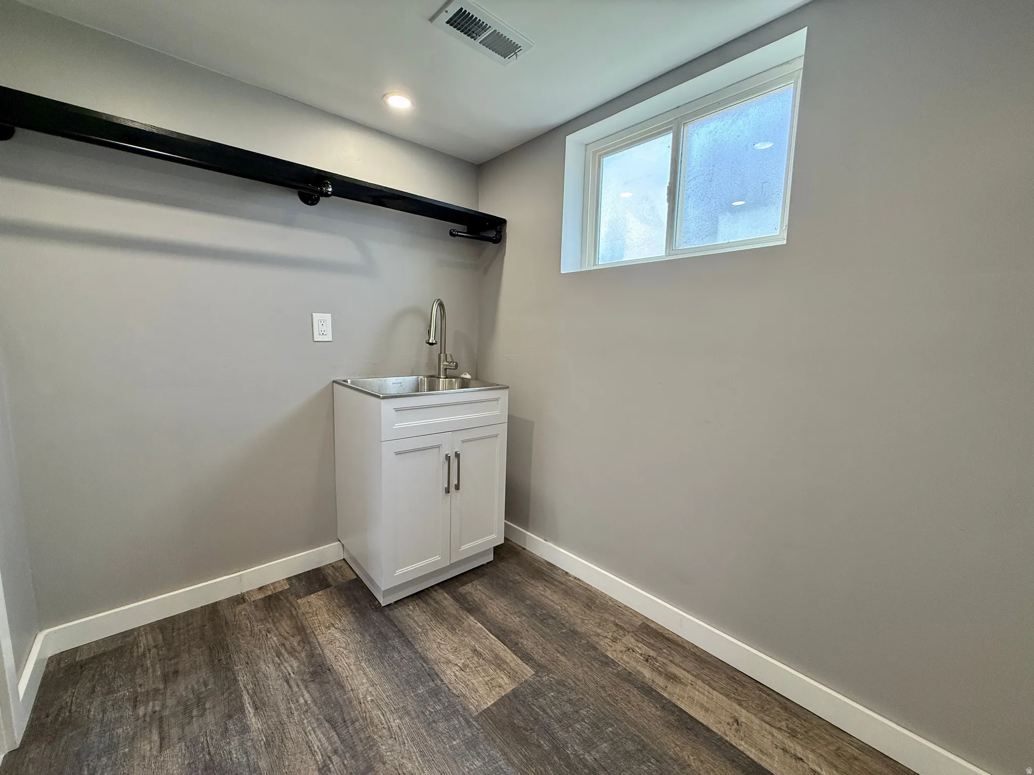 Laundry room with dark wood-style floors and recessed lighting