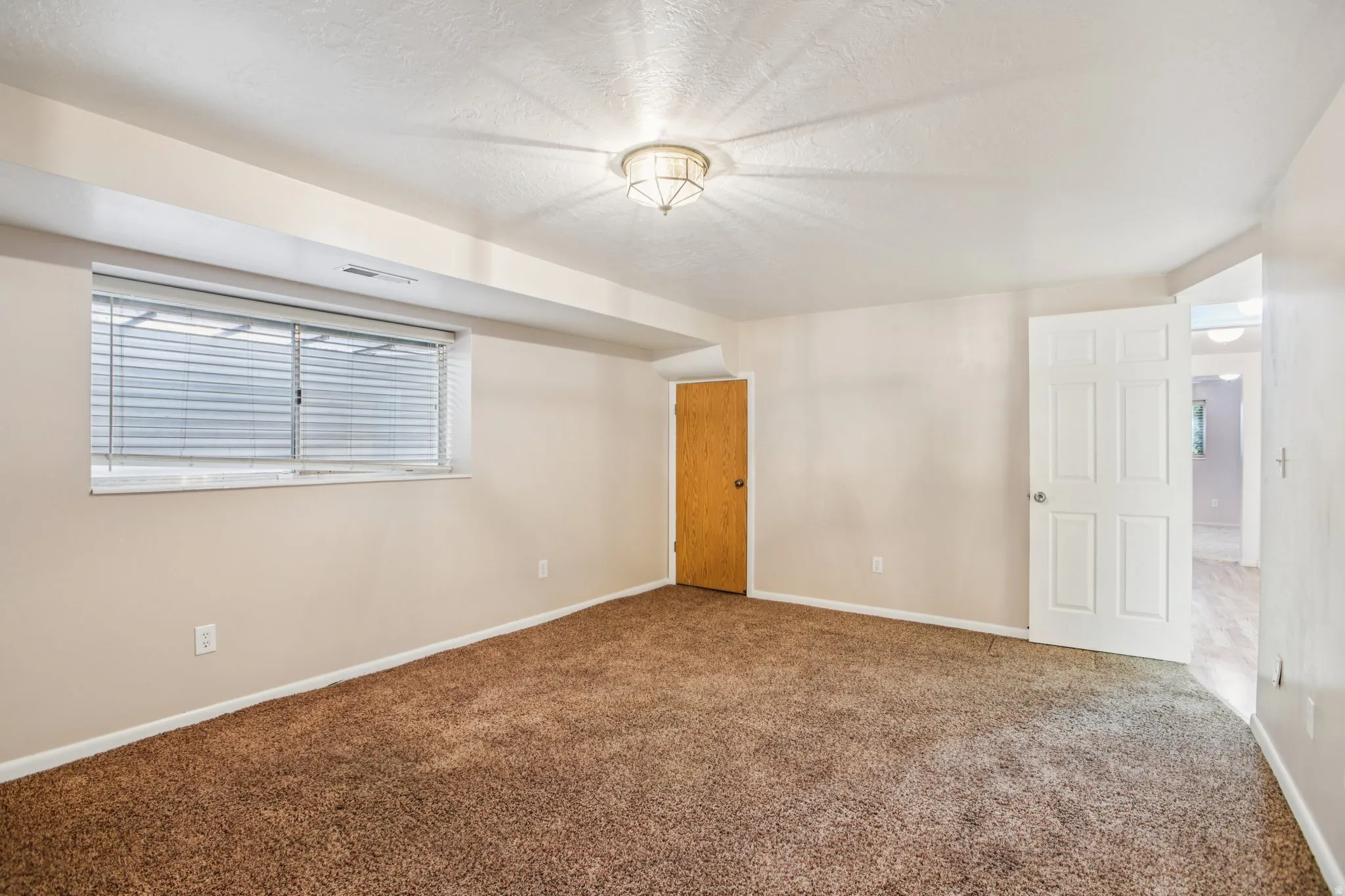 Carpeted spare room with baseboards and a textured ceiling