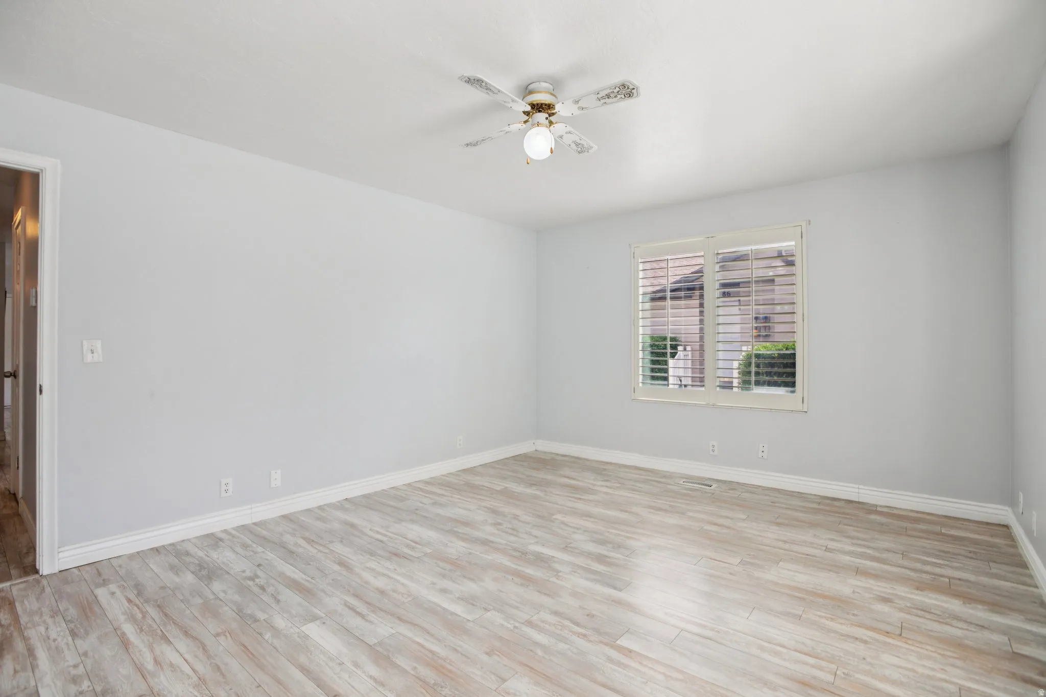 Unfurnished room featuring light wood finished floors and a ceiling fan