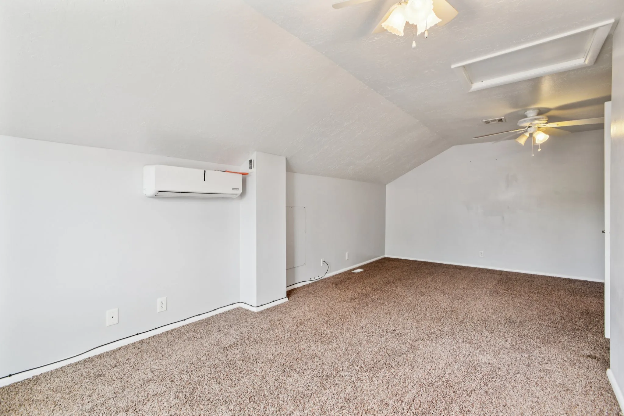 Additional living space featuring a ceiling fan, lofted ceiling, and carpet