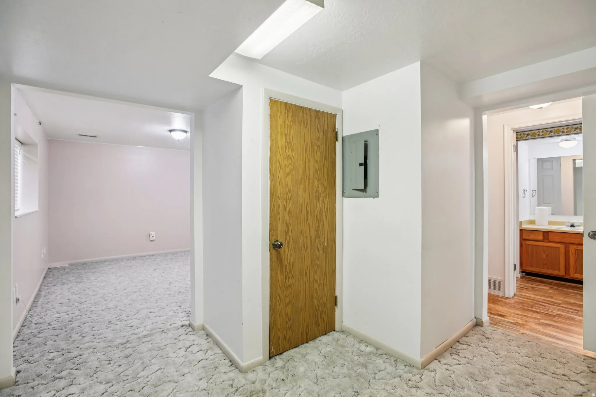 Hallway with electric panel and light carpet
