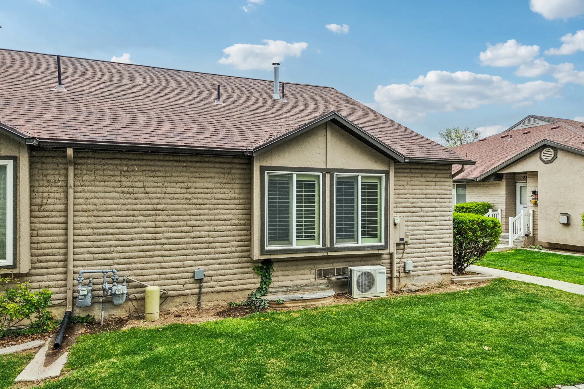Back of house with a lawn and a shingled roof