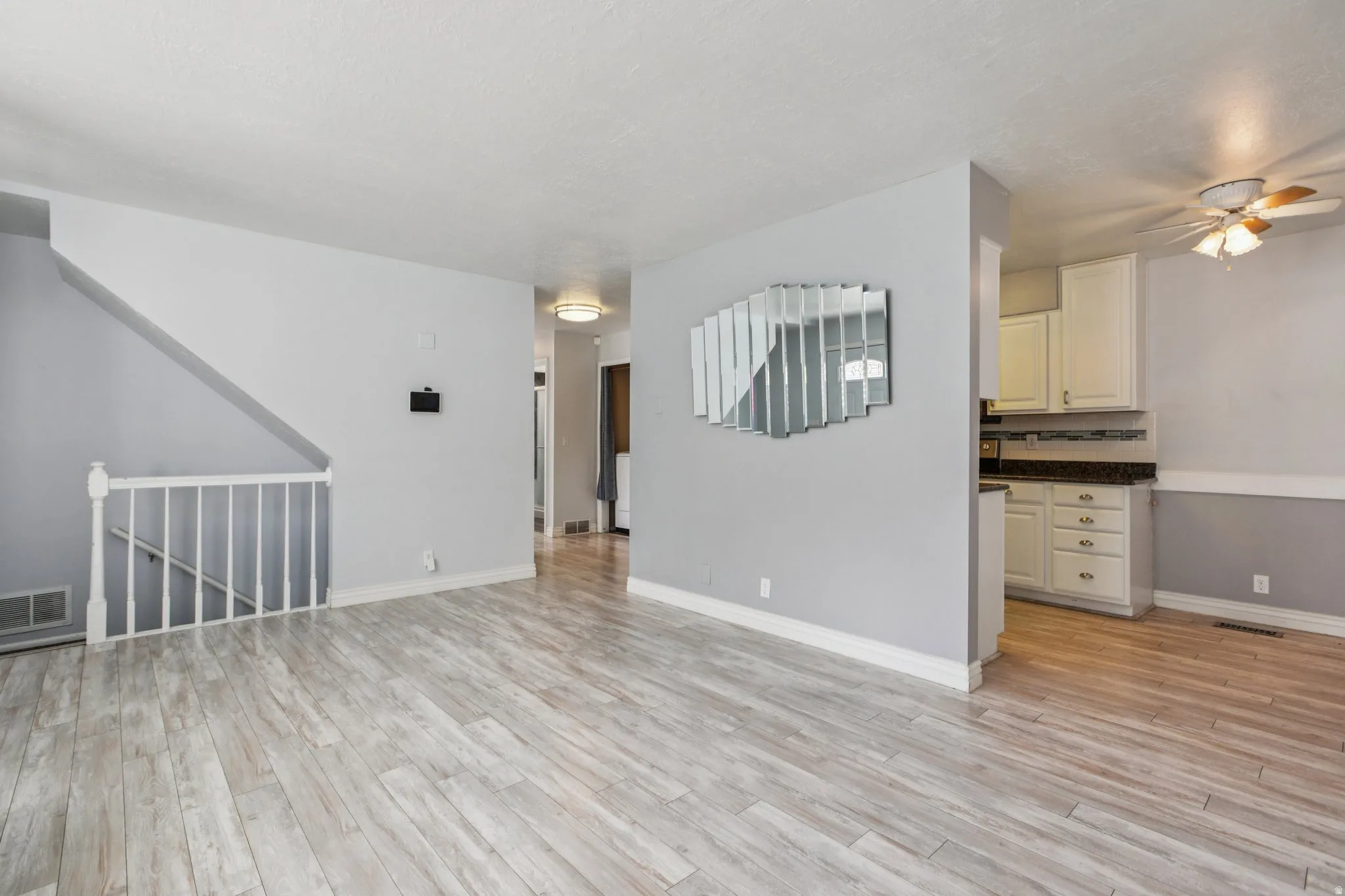 Unfurnished living room featuring ceiling fan and light wood-style floors