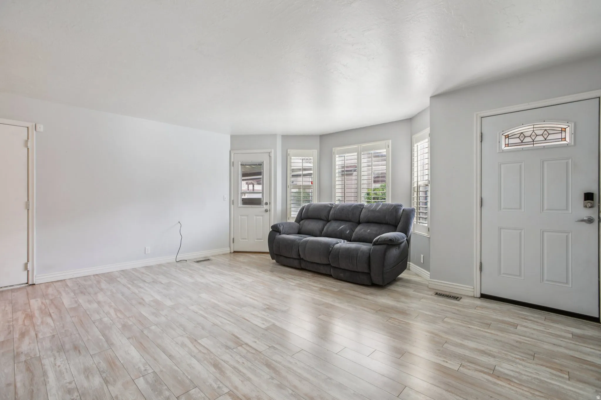 Living room featuring light wood-style flooring and baseboards