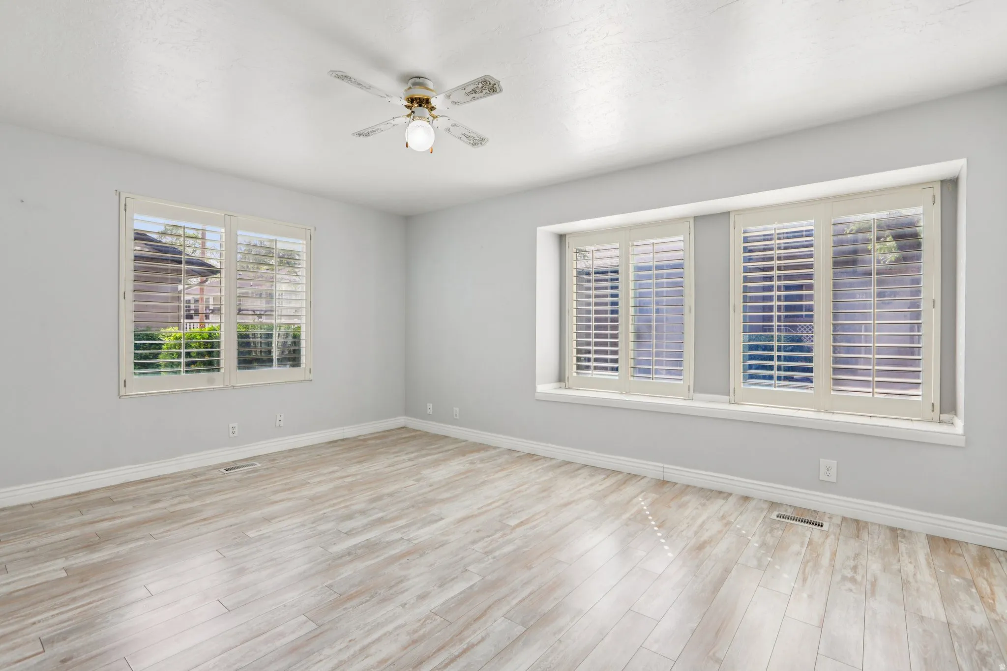 Unfurnished room with ceiling fan and light wood finished floors