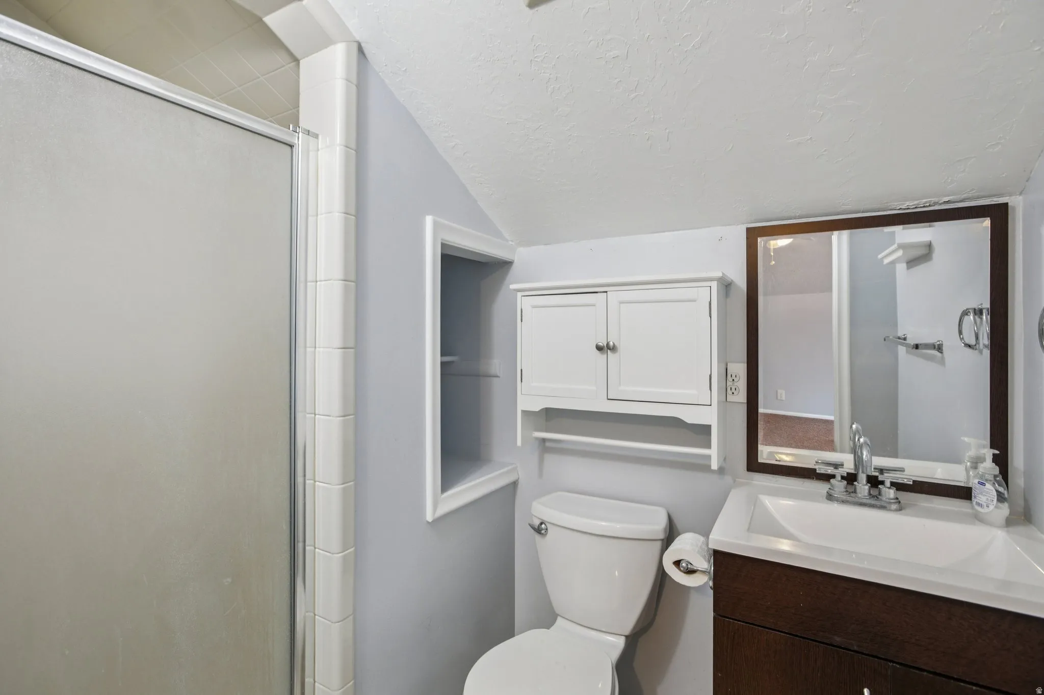 Bathroom featuring vanity and a stall shower