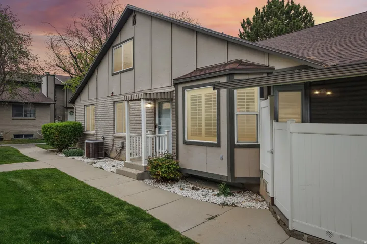 View of front of home featuring board and batten siding, a lawn, and a shingled roof