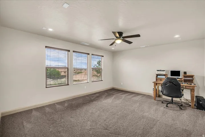 Unfurnished office featuring carpet, a ceiling fan, and recessed lighting