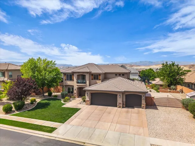 View of front of house with an attached garage, a gate, concrete driveway, a residential view, and stone siding