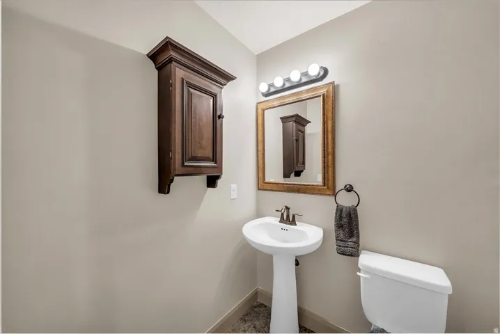 Half bath with toilet and baseboards